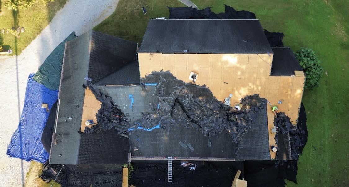 Aerial view of an active roof tear-off and replacement in Central Mississippi